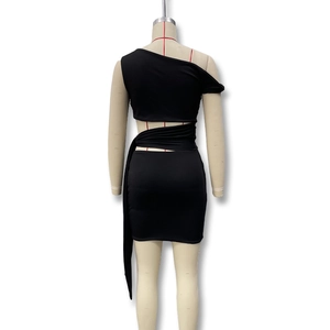 Detail of black one-shoulder dress showing waist cutout and wrap-around strap design