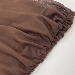 Primo piano del tessuto a rete marrone con texture arricciata e finitura trasparente