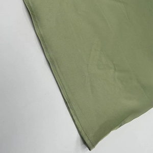 Close-up of light green mesh fabric detailing with fine horizontal texture and neat stitching