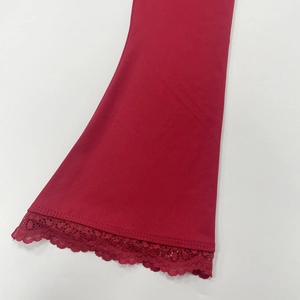 Close-up of red flared sleeve cuffs with delicate matching lace trim in elastic knit fabric