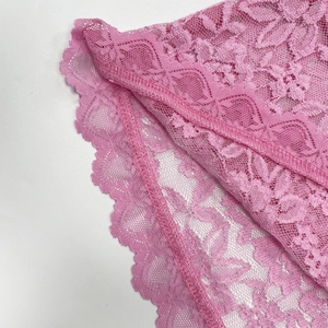 Gros plan sur la dentelle florale rose avec bords en cils et finitions festonnées