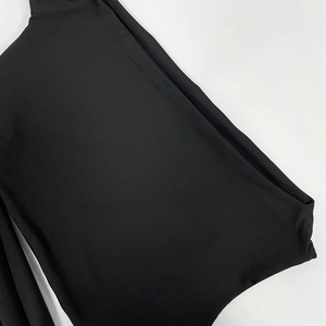 Close-up detail of smooth black elastic fabric and cut-out lace-up design of the dress