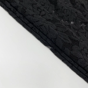 Close-up of elegant black lace fabric with intricate floral patterns and hollow mesh texture