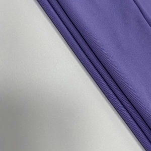 Vue détaillée du tissu en maille violet foncé haute densité avec texture lisse et élasticité