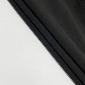 Detailed close-up showing the fine texture and soft knit fabric of this black bodycon dress