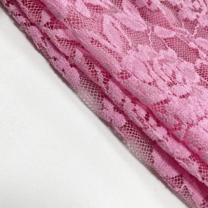 Gros plan sur la dentelle rose avec motifs floraux et détails de maille ajourée
