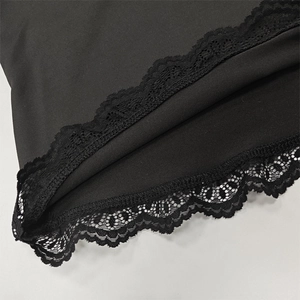 Detail shot of black garment featuring intricate floral lace trim and smooth fabric finish