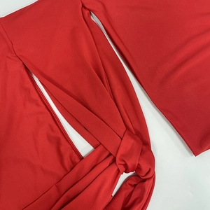 Detail of red dress showing knot design and smooth elastic fabric texture