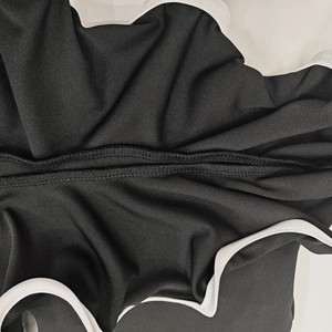 Detailansicht der verstärkten Doppelnaht und der weißen elastischen Kante am schwarzen Kleid