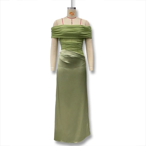 Detail of green ruched mesh bodice and sleek satin ankle-length skirt on a mannequin