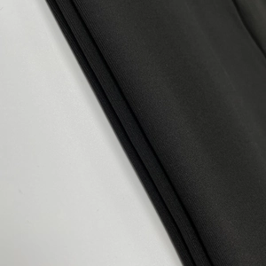 Gros plan sur un tissu en maille noire haute densité montrant texture et élasticité