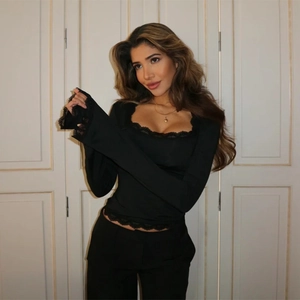 Close-up of black slim-fit top featuring delicate lace trim on the U-neckline and sleeves