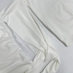 Detail view of the elegant white pleated knot design with subtle glossy fabric texture