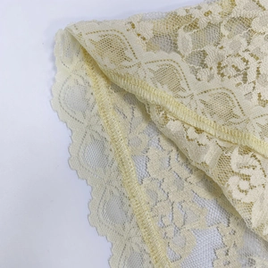Gros plan sur de la dentelle florale jaune pâle avec détails de couture surjetée précise