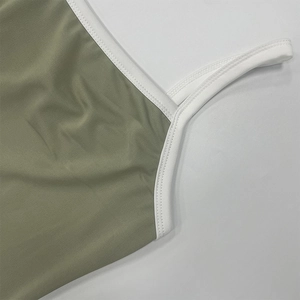 Dettaglio dell'abito in maglia a coste verde oliva con bordo bianco e cuciture precise