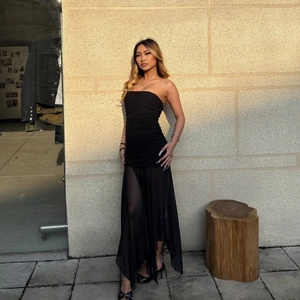 Dettaglio di abito senza spalline nero elegante con pieghe e gonna in mesh velata