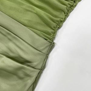 Detailed macro view of the sheer mesh and smooth green satin fabric patchwork design