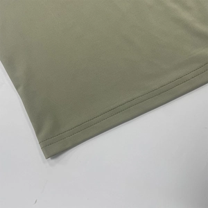 Dettaglio del tessuto a costine verde oliva e doppie cuciture resistenti sull'abito