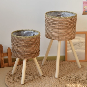 Close-up of two natural woven plant stands with solid wood legs in a Nordic style setting
