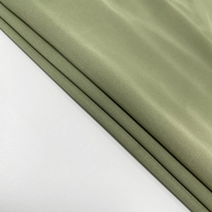 Close-up of olive green mesh fabric showing fine texture and silk-like sheen for dresses