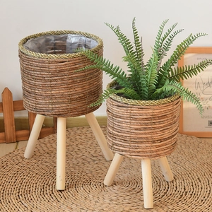 Detail view of woven plant stands with natural wood legs and waterproof inner lining
