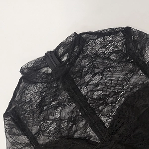 Dettaglio della trama in pizzo floreale nero e della cerniera sul colletto alto
