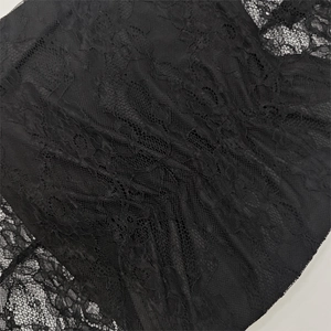 Dettaglio ravvicinato di pizzo floreale nero con intricati motivi trasparenti e traforati