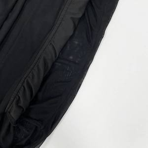 Detail view of double-layered black mesh hem and precise stitching on the dress
