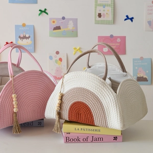Detailed view of woven cotton rope diaper caddy with rainbow pattern and bead tassels