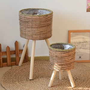 Detail of woven rattan plant stands with wooden legs and waterproof plastic lining