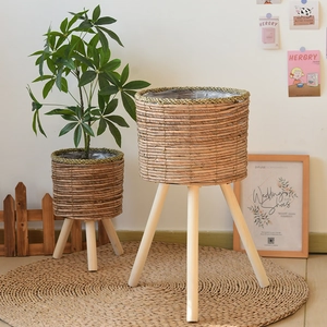 Detail of woven grass planters with solid wood legs and waterproof plastic liners
