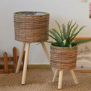 Close-up of natural seagrass woven plant stand with solid wood legs and waterproof liner