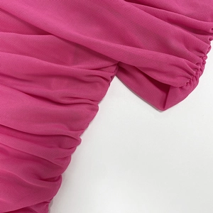 Detail of hot pink sheer mesh fabric with intricate pleats and delicate ruching texture