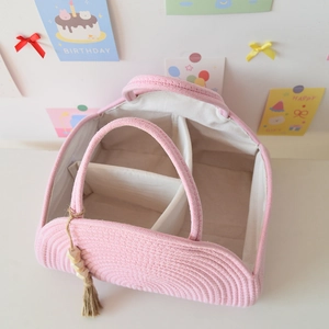 Top view of pink cotton rope diaper caddy showing internal dividers and tassel detail