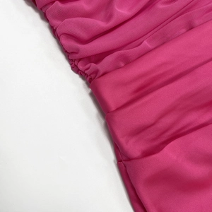 Detailed macro view of pink mesh stitching and satin fabric on the off-shoulder dress