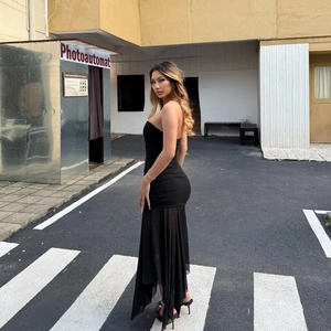 Dettaglio dell'abito a fascia nero con corpo arricciato e bordo asimmetrico in rete
