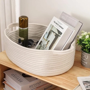 Detailed texture of white cotton rope woven storage basket with sturdy handles on wood shelf