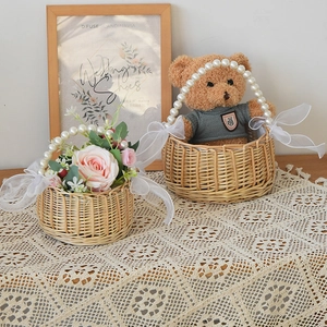 Detail of woven wicker basket with large pearl handle and soft white organza bows