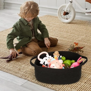 Handcrafted black cotton rope storage basket filled with toys in a cozy home setting