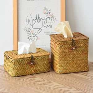 Detail of hand-woven straw tissue box set featuring wooden button and elastic closure