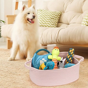 Detail of pink cotton rope woven basket filled with various pet toys on a plush rug