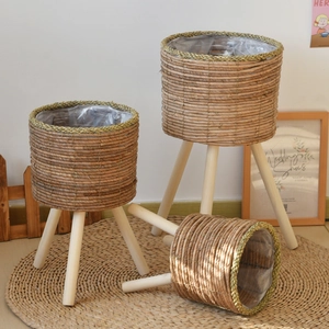 Three-piece set of woven rattan plant stands with wooden legs in various sizes for home decor