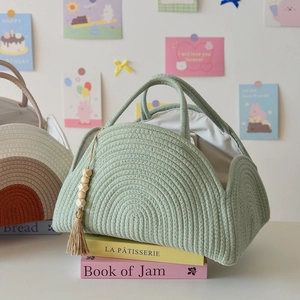 Close-up of woven cotton rope diaper caddy with wooden bead tassel and soft lining