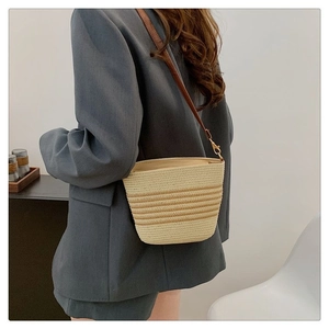 Elegante borsa a secchiello in paglia intrecciata con tracolla in pelle per l'estate