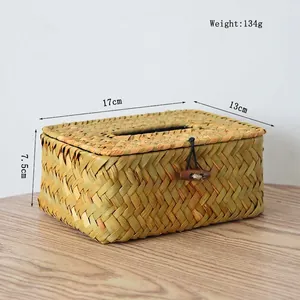 Detail of hand-woven straw tissue box showing natural fiber texture and wood button closure