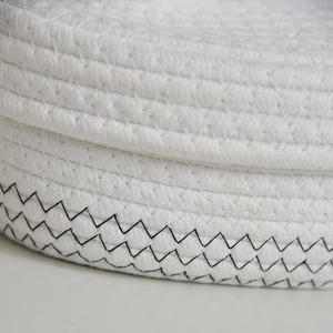 Macro detail of white woven cotton rope tissue box with black zigzag stitching accents