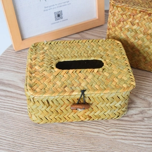 Detail of hand-woven straw tissue box showing natural fiber texture and wood button closure