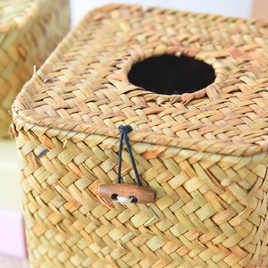 Close-up of handmade straw tissue box with natural woven texture and wooden button closure