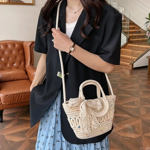 Sac seau en paille beige avec nœud en dentelle et perle, porté main ou en bandoulière