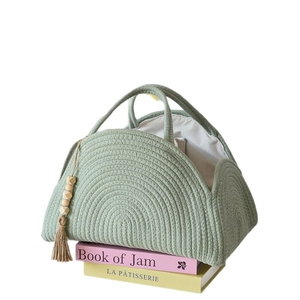 Sage green woven cotton rope diaper caddy with wood bead tassels and soft fabric lining